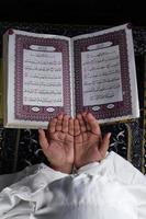 barn hand bön- med Uppfostrad händer mot de quran bakgrund. islamic begrepp foto