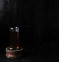 glas kopp av te på svart bakgrund foto