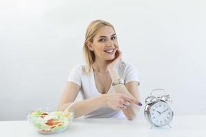 tid till tappa bort vikt , äter kontrollera eller tid till diet begrepp. retro larm klocka i som kvinna göra intermittent fasta med en friska mat av sallad. foto