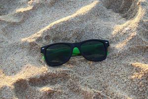 resa till ö phuket, thailand. de solglasögon på de sand i de solig väder. foto