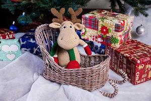 stickat älg. söt älg. leksak mot de bakgrund av en ny år krans, stickat hare och älg på en jul träd foto