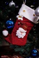 jul strumpa. röd strumpa med snöflingor för jultomten gåvor hängande på de jul träd. vinter- högtider foto