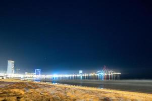 Mazatlan sinaloa strand på natt med lysande stad i de bakgrund foto