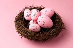 närbild av rosa ägg i de bo på rosa bakgrund . foto