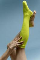 kvinna med skön ben bär grön strumpor på henne fötter. isolerat på blå bakgrund foto