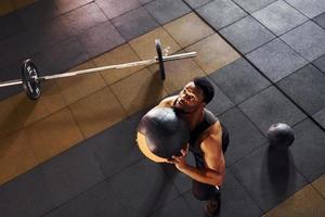 spelar basketboll. stark afrikansk amerikan man i sportigt kläder ha träna dag i de Gym foto