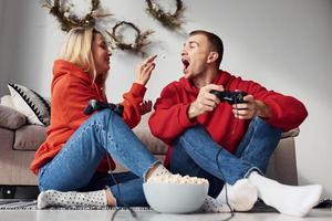 ung härlig par tillsammans på Hem spelar video spel på helgen och högtider tid tillsammans foto