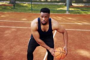 afrikansk amerikan man spelar basketboll på de domstol utomhus foto