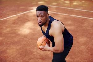 afrikansk amerikan man spelar basketboll på de domstol utomhus foto