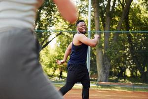 afrikansk amerikan man med flicka spelar basketboll på de domstol utomhus foto