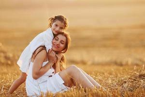 Lycklig mor med henne liten dotter utgifterna tid tillsammans utomhus på de fält foto