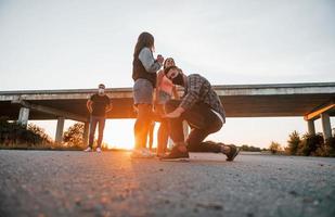 gående på de väg. grupp av ung glad vänner har roligt tillsammans. fest utomhus foto