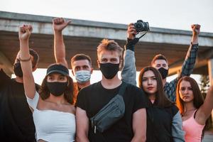 fotograf med kamera. grupp av protesterar ung människor den där stående tillsammans. aktivist för mänsklig rättigheter eller mot regering foto