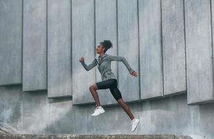 uppfattning av sport. ung afrikansk amerikan kvinna i sportigt kläder ha träna utomhus på dagtid foto
