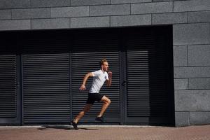 stretching och förbereder. ung man i sportigt kläder ha träna utomhus på dagtid foto