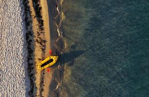 topp se av gul båt den där parkerad på de kust av hav på dagtid foto