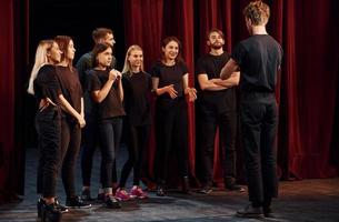 grupp av aktörer i mörk färgad kläder på repetition i de teater foto