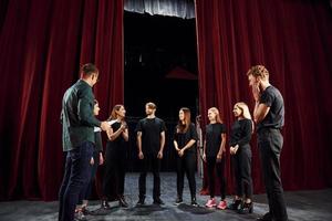 arbetssätt tillsammans. grupp av aktörer i mörk färgad kläder på repetition i de teater foto