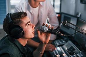 uppfattning av lagarbete. två grabbar är inomhus i de radio studio är upptagen förbi utsända foto