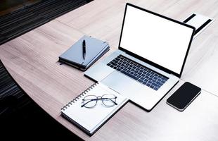 topp se vit skärm på visa bärbar dator med anteckningsbok och glasögon på tabell i möte rum foto