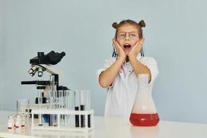 rädd liten flicka i täcka spelar en forskare i labb förbi använder sig av Utrustning foto