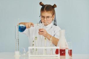 liten flicka i täcka spelar en forskare i labb förbi använder sig av Utrustning foto