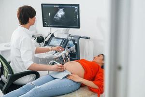 ultraljud diagnostisk. gravid kvinna är i de klinik i skåp och ha hälsa kolla upp foto
