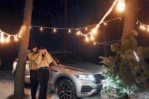 uppfattning av kärlek. par stående i de skog och fira ny år foto