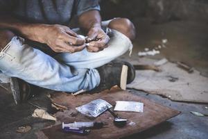 mänsklig hand av en läkemedel missbrukare och en spruta med narkotisk spruta liggande på de golv, värld anti läkemedel dag. foto