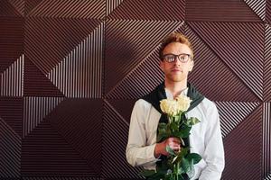 man innehar blommor. inomhus av ny modern lyx restaurang foto