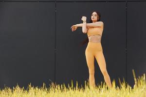 håller på med övningar. ung kvinna i sportkläder ha kondition session utomhus foto
