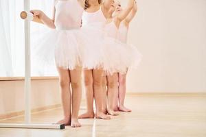 stänga upp se. liten ballerinor framställning för prestanda förbi praktiserande dansa rör sig foto