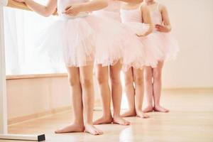 stänga upp se. liten ballerinor framställning för prestanda förbi praktiserande dansa rör sig foto