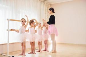arbetssätt med tränare. liten ballerinor framställning för prestanda förbi praktiserande dansa rör sig foto