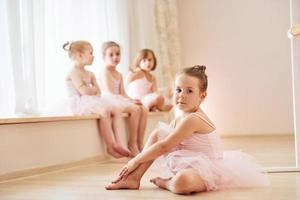 flickor sitter på fönsterkarm och på de golv. liten ballerinor framställning för prestanda foto