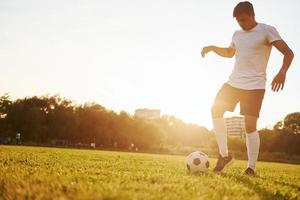 håller på med annorlunda knep. ung fotboll spelare ha Träning på de sportigt fält foto