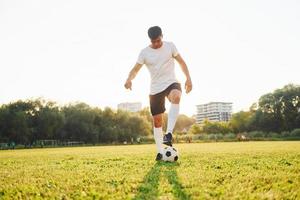 ett person endast. ung fotboll spelare ha Träning på de sportigt fält foto