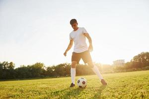 skön solsken. ung fotboll spelare ha Träning på de sportigt fält foto