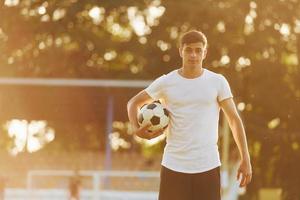 stående och Framställ. ung fotboll spelare ha Träning på de sportigt fält foto