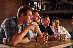 dricka öl. människor i tillfällig kläder Sammanträde i de pub foto