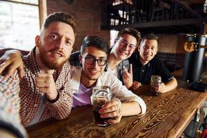 framställning selfie. människor i tillfällig kläder Sammanträde i de pub foto