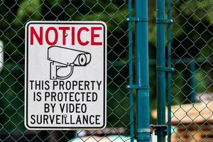 lägga märke till privat fast egendom video övervakning tecken på kedja länk staket foto