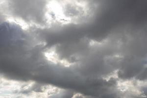 tung mörk moln med solljus slingor foto