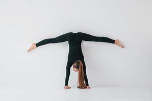 öva rutin. ung kvinna i sportigt kläder håller på med gymnastik inomhus foto