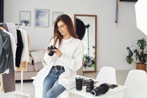 kvinna fotograf i tillfällig kläder är arbetssätt inomhus på dagtid foto