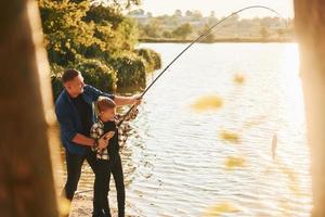 några mat till äta. far och son på fiske tillsammans utomhus på sommartid foto