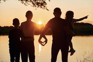 ser på solnedgång. familj av mor, far och barn är på de camping foto