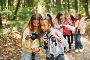 uppfattning av turism. barn i grön skog på sommar dagtid tillsammans foto
