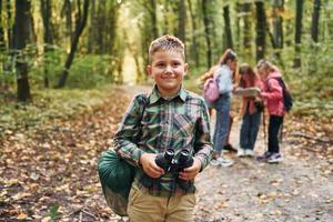 uppfattning av vandring. barn i grön skog på sommar dagtid tillsammans foto