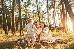 positiv känslor. Lycklig familj av far, mor och liten dotter är i de skog foto